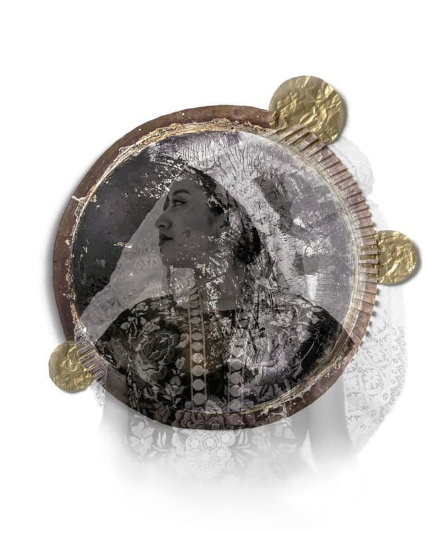 Round, sculptural frame with gold details holds the image of a woman's profile.