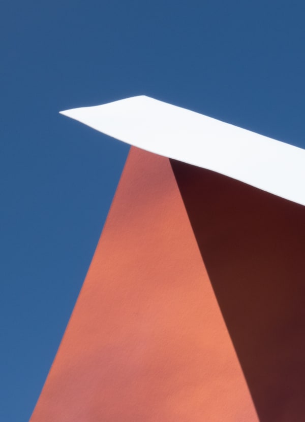 Orange and maroon abstract triangles with a white rectangle on a blue background.
